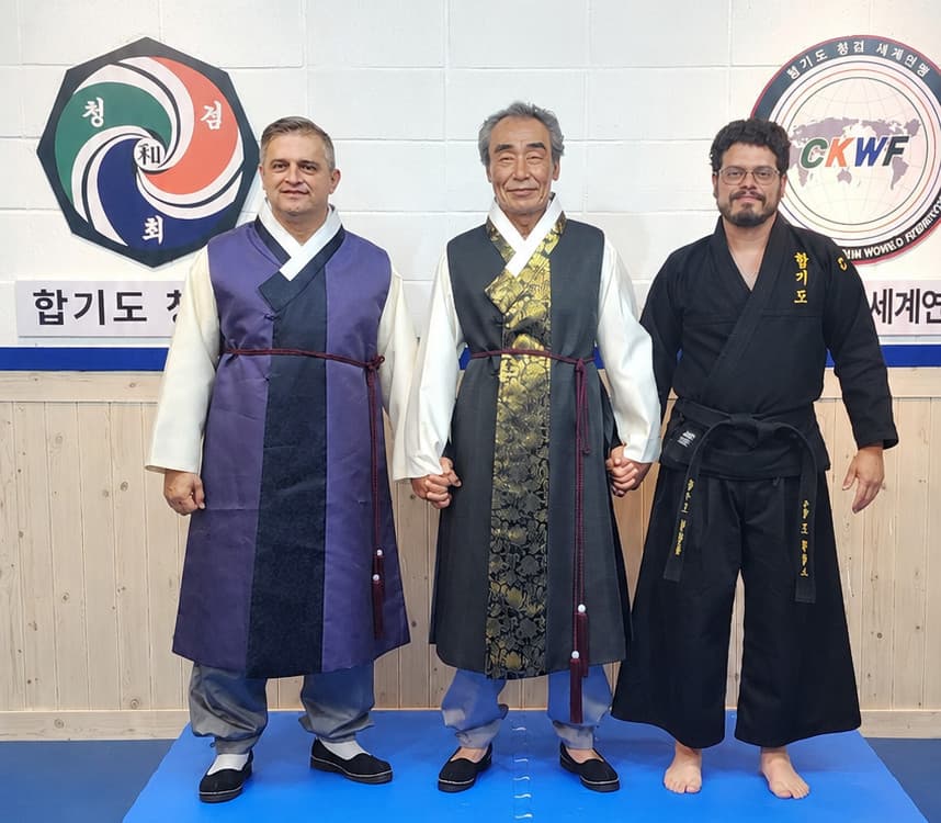 Master Joe Phillips con el Founder Lee, Seung-Woo y Grand Master William Rayo en hanbok ceremonial, sede oficial del CKWF, Seúl, Corea, 2024